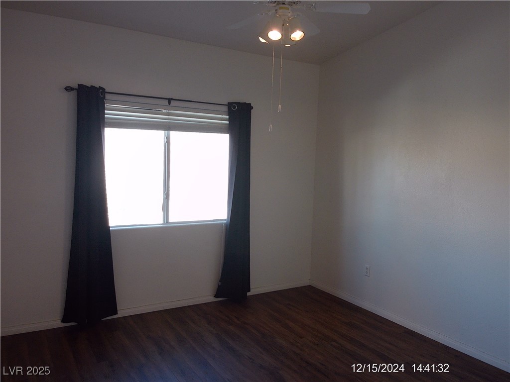 855 North Stephanie Street, Unit 2526 Henderson, NV 89014 - Photo 17 of 26 Empty room featuring a ceiling fan and dark wood-style flooring