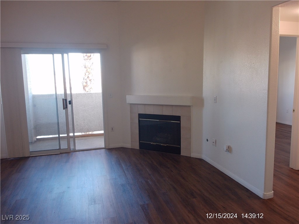 855 North Stephanie Street, Unit 2526 Henderson, NV 89014 - Photo 3 of 26 Unfurnished living room with a fireplace and dark wood-style floors
