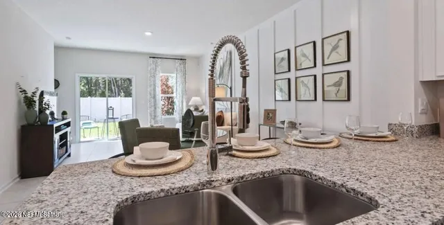 a kitchen with a granite countertop sink and a stove