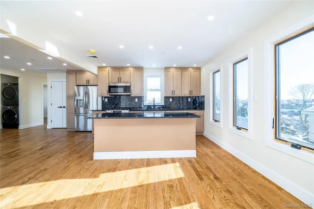 a large kitchen with stainless steel appliances granite countertop a stove a sink and a refrigerator