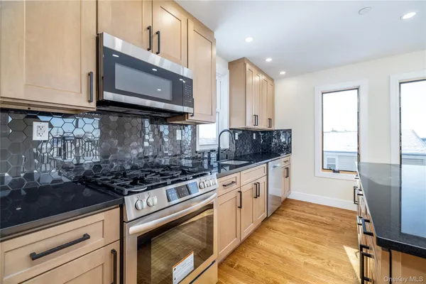 a kitchen with stainless steel appliances granite countertop a stove a sink and a microwave