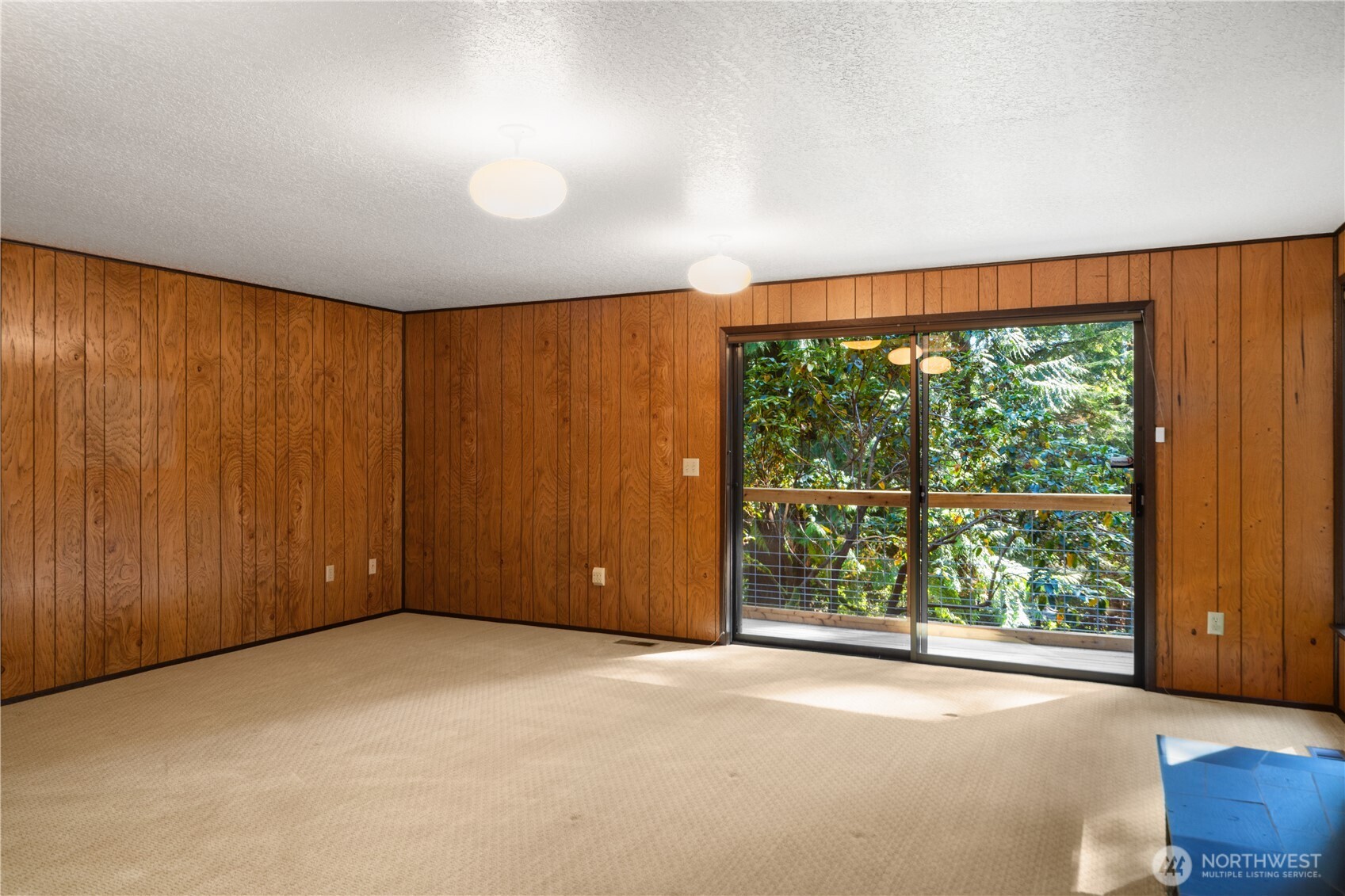 91 Drew Lane Port Ludlow, WA 98365 - Photo 28 of 38 an empty room with large windows and wooden walls