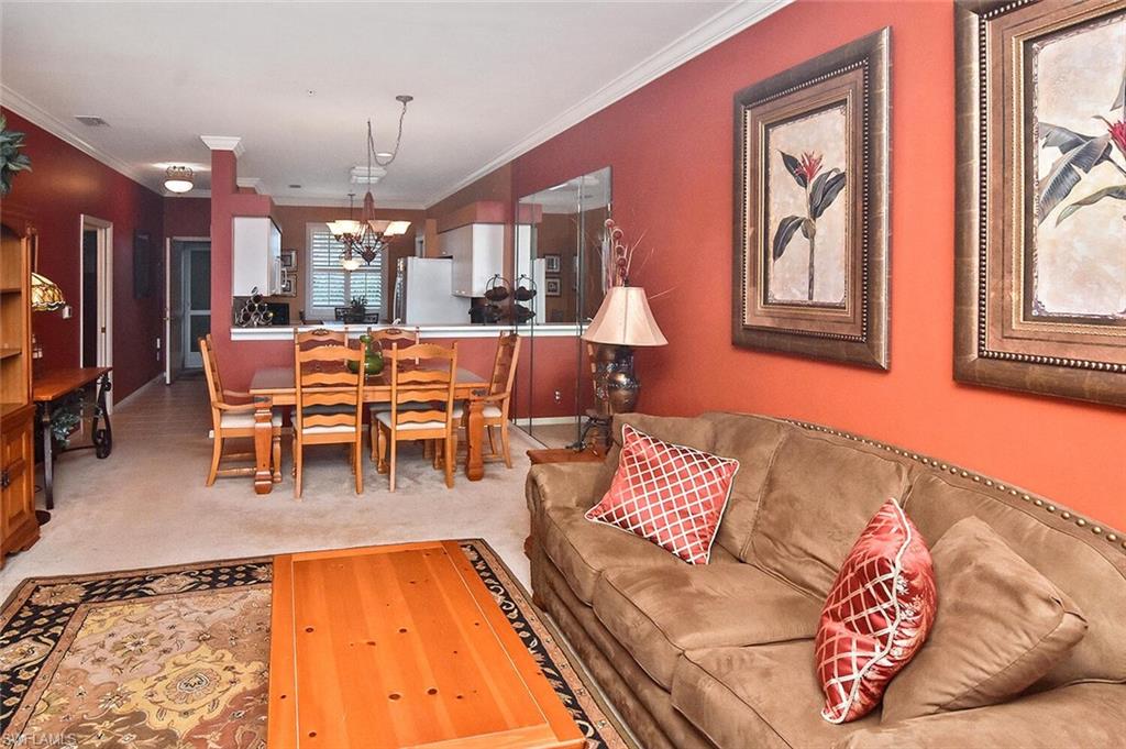 3800 Sawgrass Way, Unit 3143 Naples, FL 34112 - Photo 24 of 45 Living room with light carpet, ornamental molding, and a chandelier