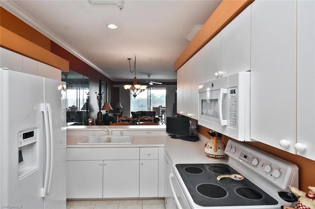 3800 Sawgrass Way, Unit 3143 Naples, FL 34112 - Photo 32 of 45 Kitchen with white appliances, white cabinets, crown molding, light countertops, and decorative light fixtures