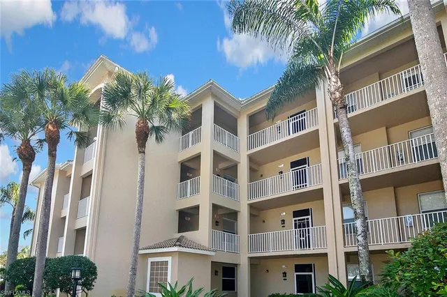 a front view of a multi story building with yard and entryway
