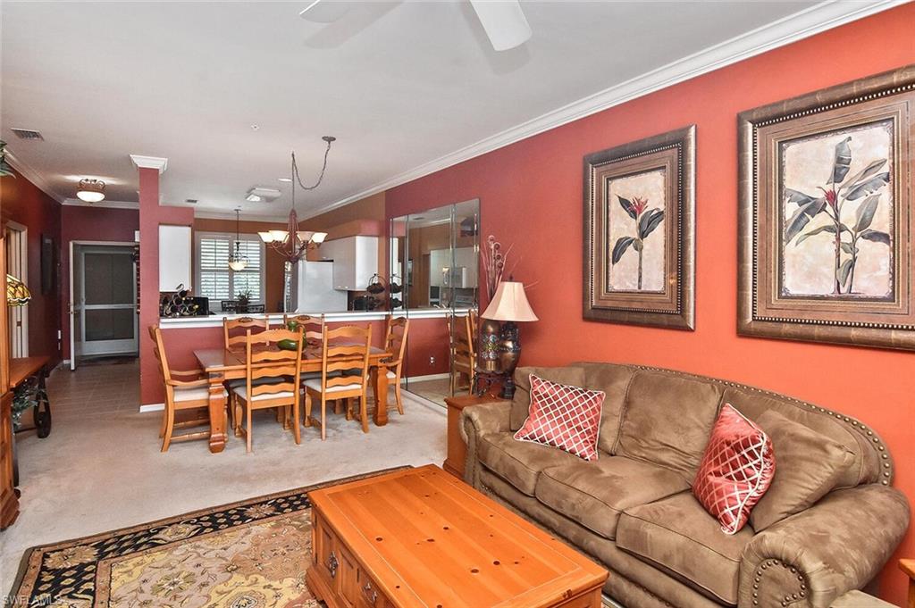 3800 Sawgrass Way, Unit 3143 Naples, FL 34112 - Photo 9 of 45 Living area featuring light carpet, ornamental molding, a chandelier, and a ceiling fan