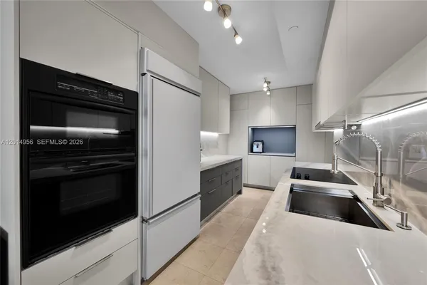 a large white kitchen with stainless steel appliances