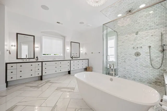 a spacious bathroom with a double vanity sink a mirror a bathtub and shower