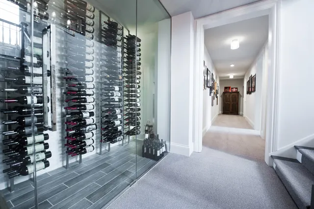 a view of a hallway with wooden floor and a living room