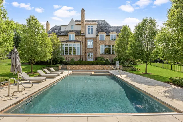 a view of a house with swimming pool and sitting area