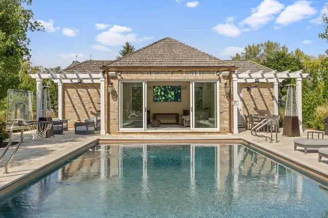 a view of a house with a swimming pool and sitting area