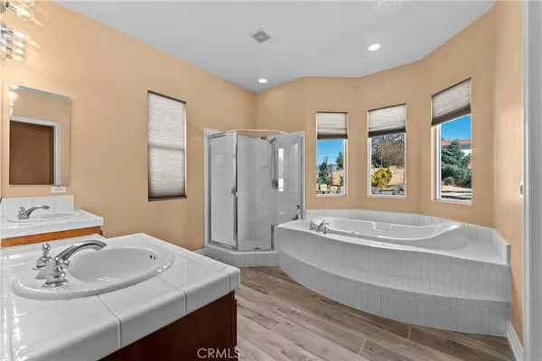 a spacious bathroom with a tub sink and mirror