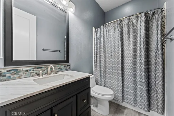 a bathroom with a double vanity sink toilet and a mirror