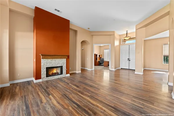 a view of a livingroom with wooden floor and a fireplace