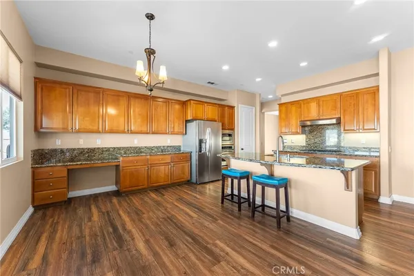 a kitchen with stainless steel appliances wooden floor sink stove and wooden cabinets