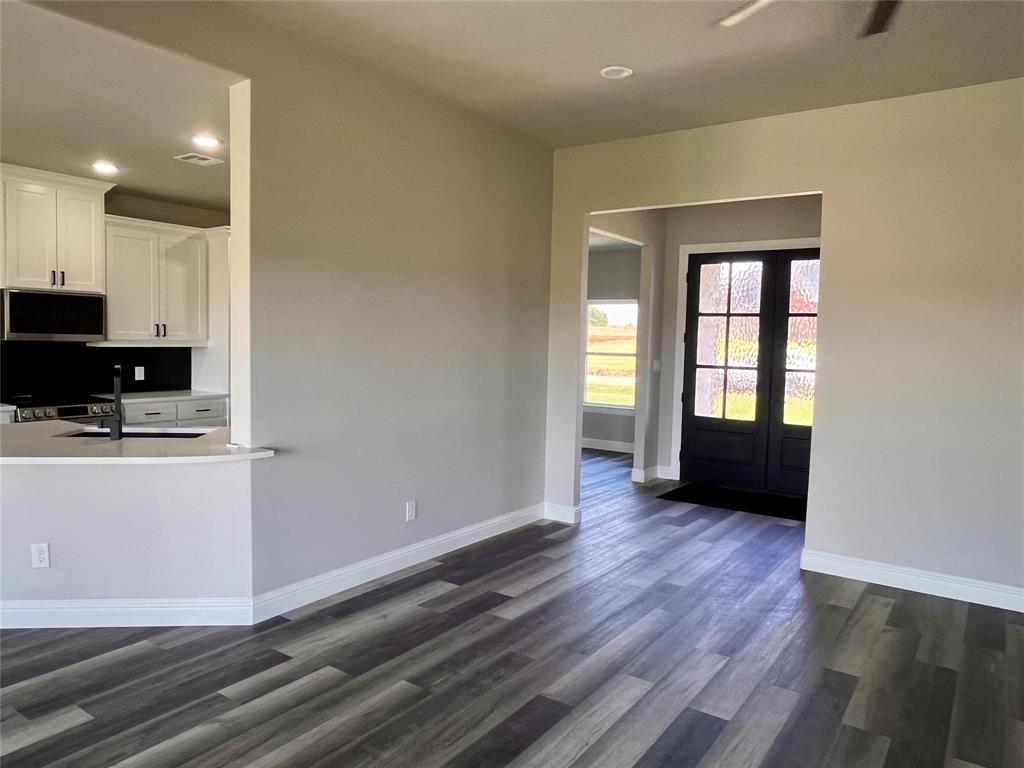1404 Dixie Road Whitesboro, TX 76273 - Photo 16 of 35 a view of kitchen with microwave and wooden floor