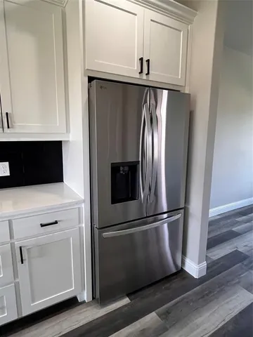 a metallic refrigerator freezer sitting in a kitchen