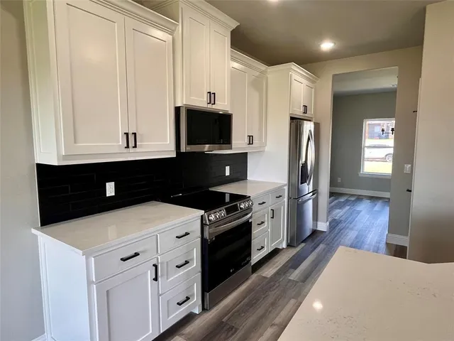 a kitchen with stainless steel appliances a stove microwave and refrigerator