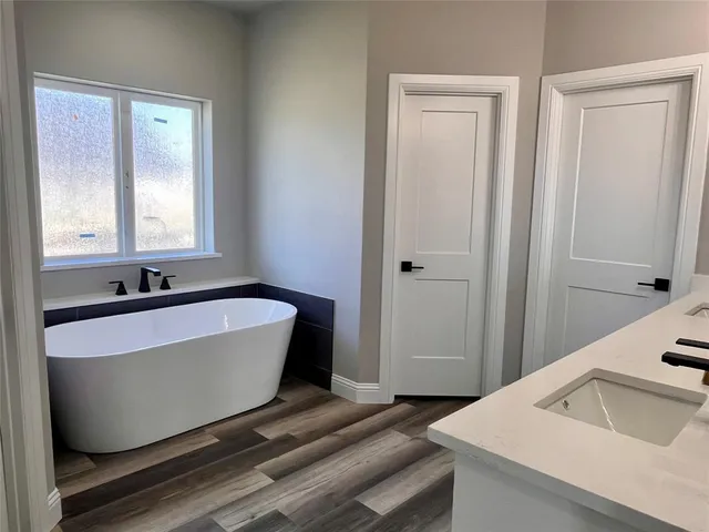 a bathroom with a tub sink and mirror