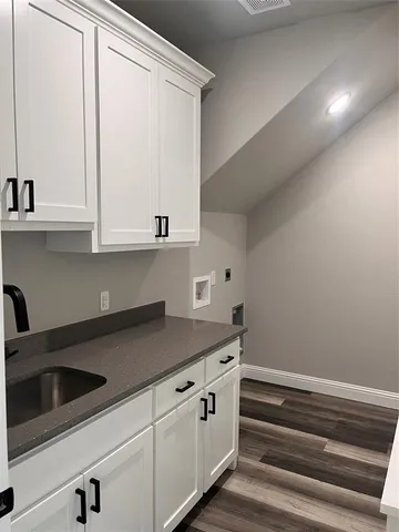 a kitchen with granite countertop white cabinets and a sink