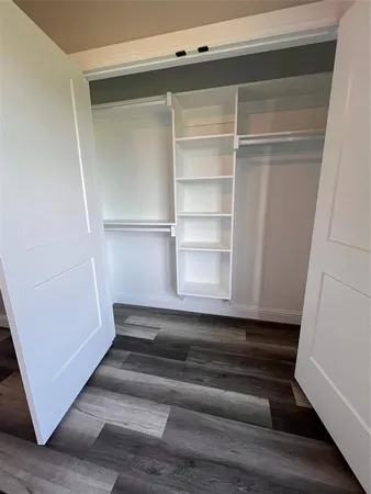 a view of walk in closet with empty racks