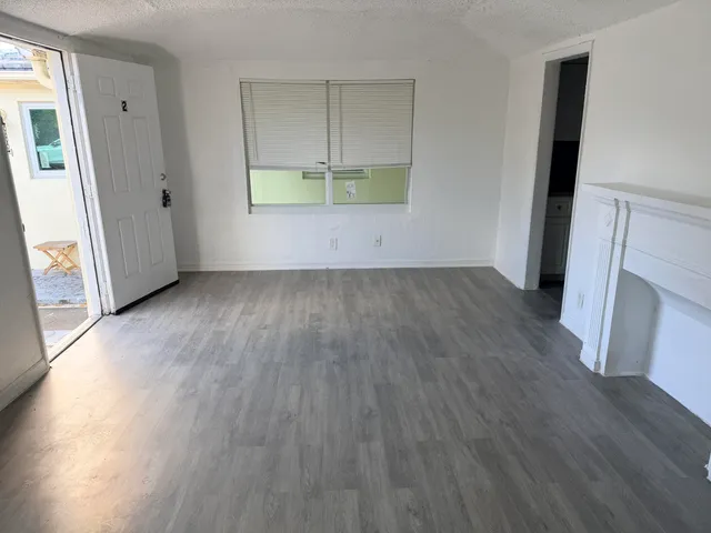 an empty room with wooden floor and a window