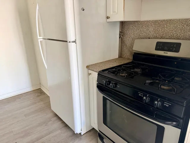 a stove top oven sitting inside of a kitchen