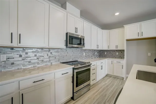 a kitchen with granite countertop white cabinets and white appliances