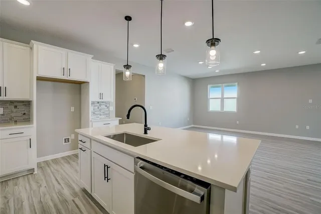 a kitchen with granite countertop a sink a counter space appliances and cabinets