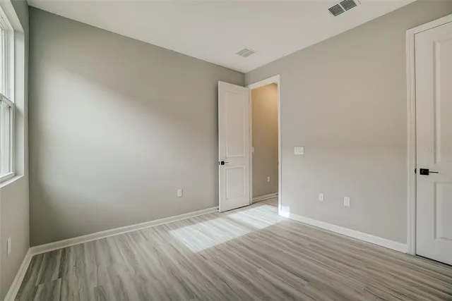 a view of an empty room with wooden floor