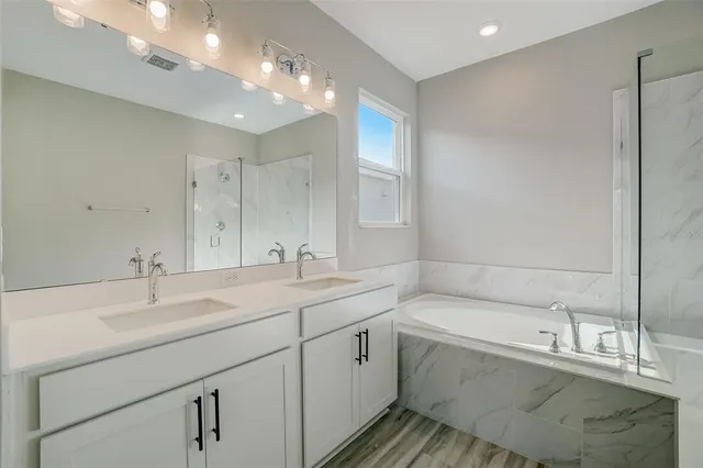a bathroom with a tub sink and mirror