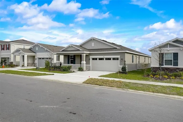 a view of a big house with a big yard and large trees