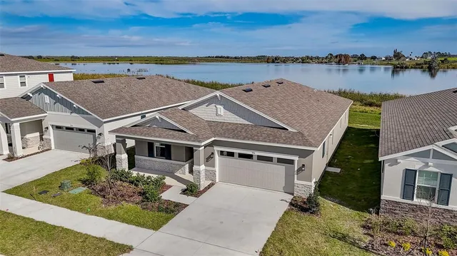 an aerial view of a house with a yard and lake view
