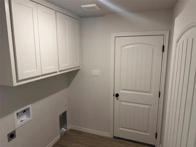an empty room with a chandelier fan and windows