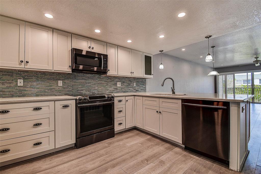 14865 Seminole Trail Seminole, FL 33776 - Photo 12 of 54 a kitchen with stainless steel appliances granite countertop a stove a sink and a microwave