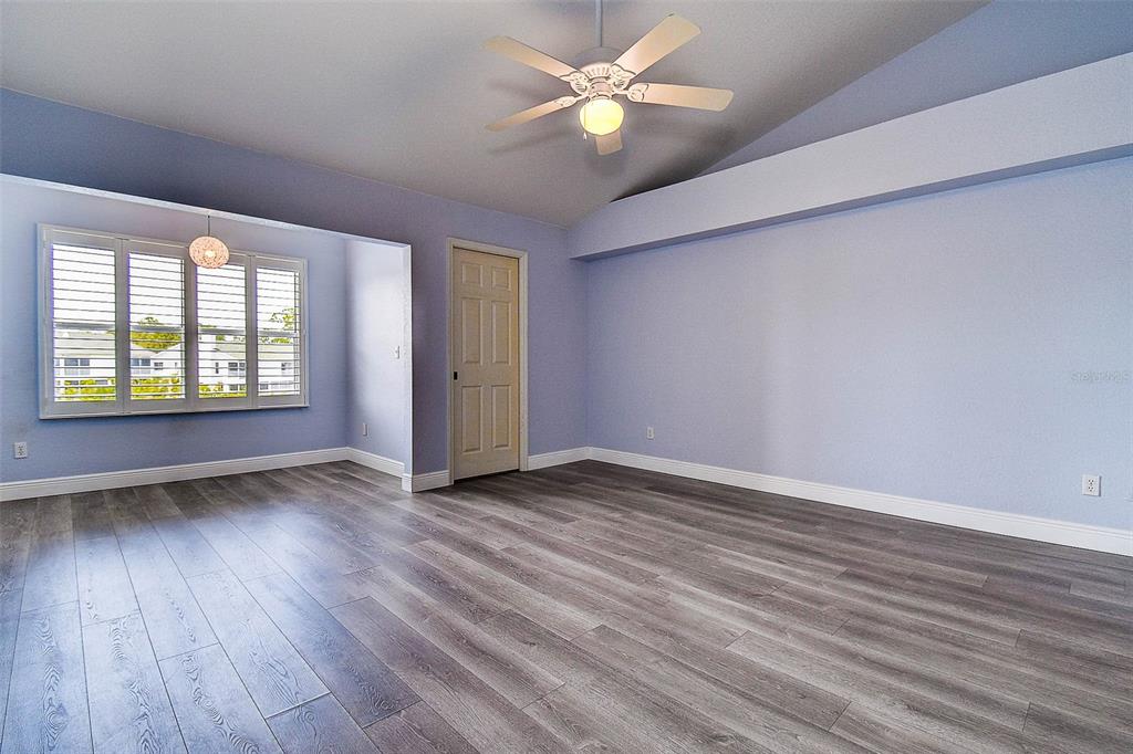 14865 Seminole Trail Seminole, FL 33776 - Photo 27 of 54 an empty room with wooden floor ceiling fan and windows