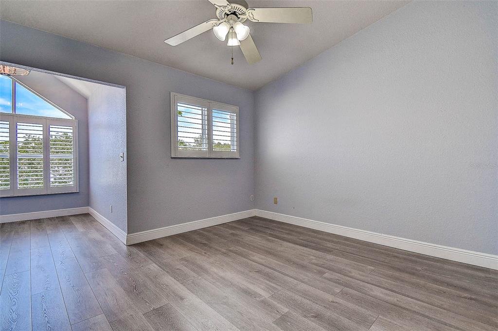 14865 Seminole Trail Seminole, FL 33776 - Photo 31 of 54 an empty room with wooden floor chandelier fan and windows
