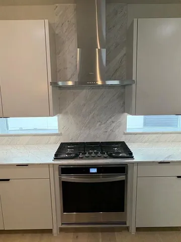 a kitchen with white cabinets and black appliances