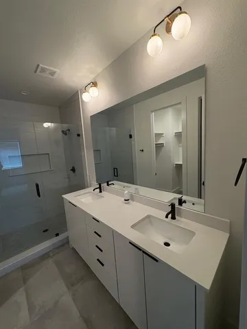 a bathroom with a sink double vanity and a mirror