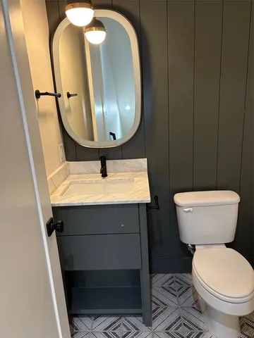 a bathroom with a toilet sink and mirror