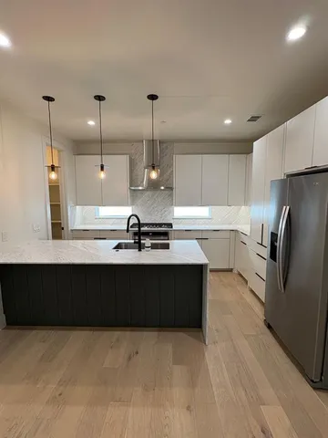 a kitchen with kitchen island a counter top space appliances and a ceiling fan