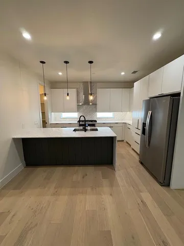 a kitchen with a refrigerator a sink and wooden cabinets