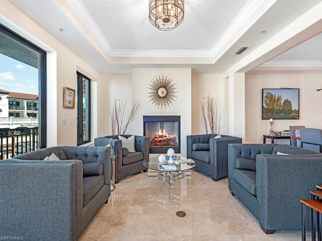 1530 5th Avenue South, Unit C206 Naples, FL 34102 - Photo 3 of 16 a living room with furniture a fireplace and a table