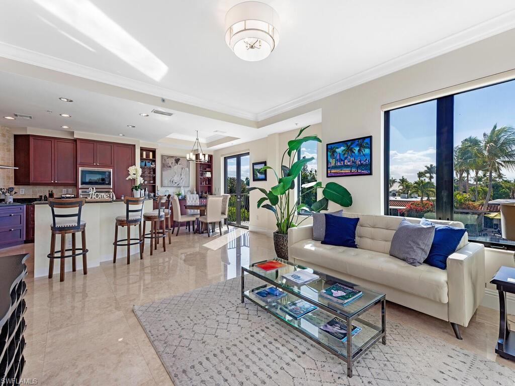 1530 5th Avenue South, Unit C206 Naples, FL 34102 - Photo 4 of 16 a living room with furniture and a dining table with kitchen view