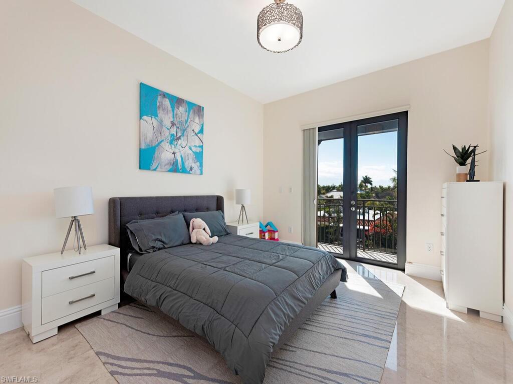 1530 5th Avenue South, Unit C206 Naples, FL 34102 - Photo 10 of 16 a bedroom with a bed and a large window