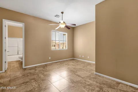 an empty room with windows and chandelier fan