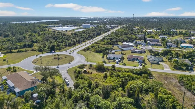 an aerial view of residential houses with outdoor space and trees