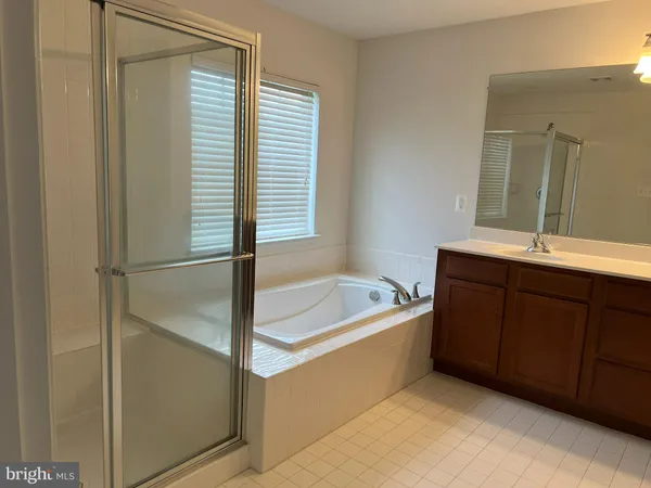 a bathroom with a tub sink and mirror