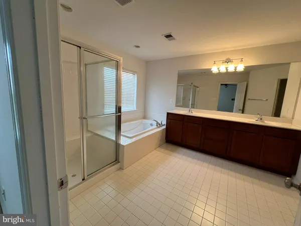 a spacious bathroom with a double vanity sink and a mirror