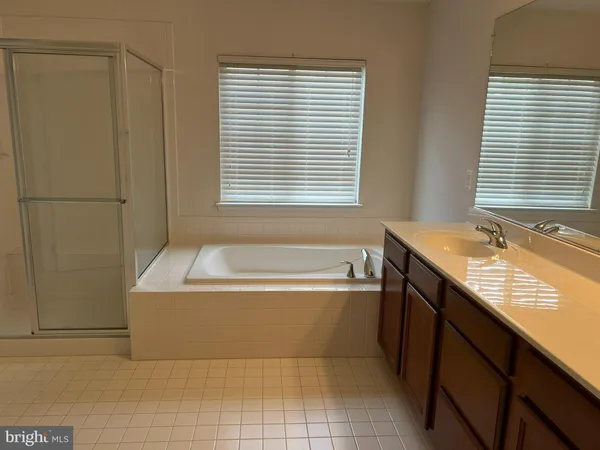 a bathroom with a granite countertop sink and a bathtub